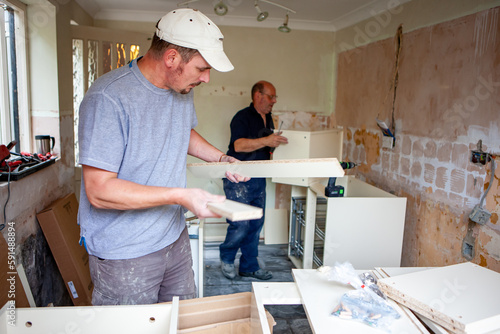 Kitchen Fitters: Flat Pack Build. A pair of carpenters building the carcass to a new fitted kitchen. From a series of related images. photo