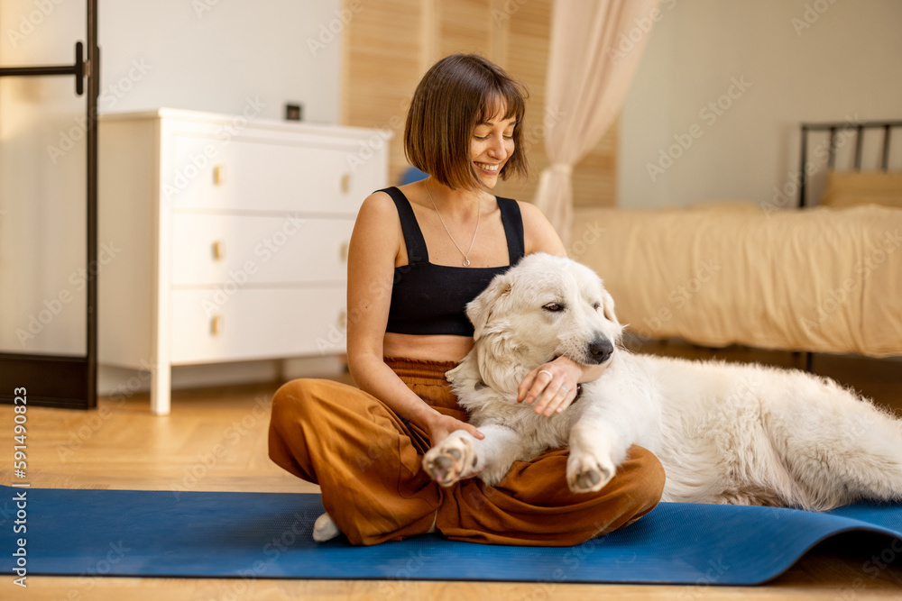 Young woman cares her cute dog, hugs together while doing yoga at home. Concept of dog therapy and mental health Young woman cares her cute dog, hugs together while doing yoga at home. Concept of dog therapy and mental health