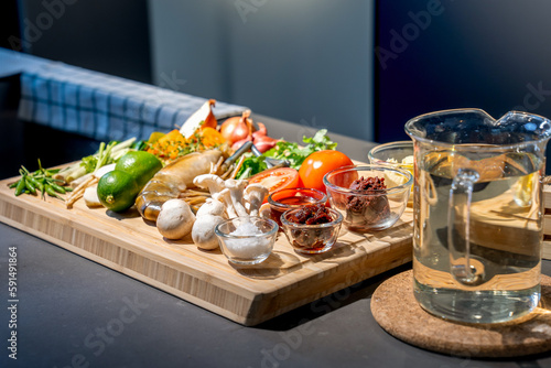 Ingredients of TomYamKung (Shrimp Spicy Thai Soup) is a lemon, prawn, chilli, lemon grass, onion, tomato, mushroom and condiment sauce on the kitchen counter.