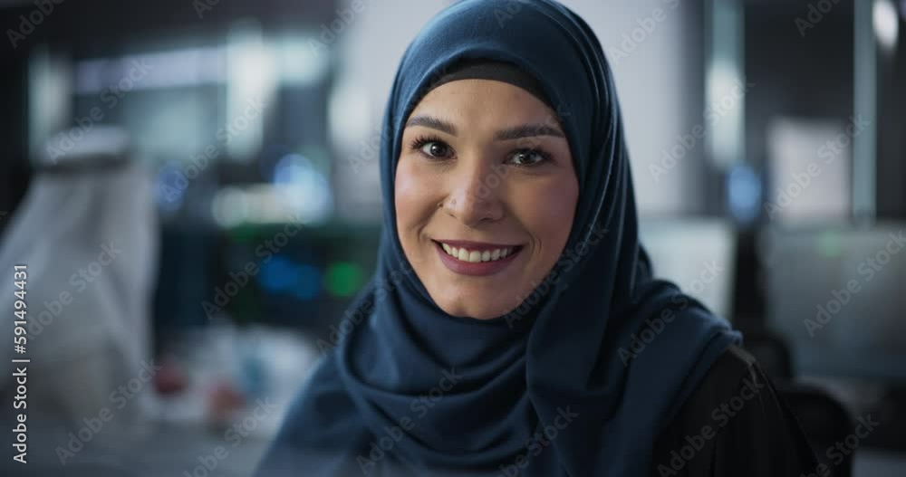 Portrait of a Young Empowered Arab Woman in Hijab Looking at Camera and Charmingly Smiling. Middle Eastern Specialist at Work, Information Technology Manager, Software Engineering Professional Portrait of a Young Empowered Arab Woman in Hijab Looking at Camera and Charmingly Smiling. Middle Eastern Specialist at Work, Information Technology Manager, Software Engineering Professional