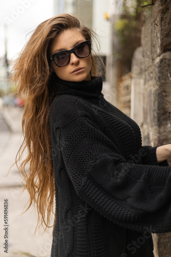 details of the face of a latin woman with long wavy hair  sunglasses on a sunny day  beauty and glamor  person portrait