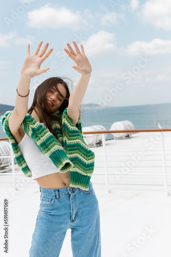 Photography Carefree traveler with sweater outstretching hands during cruise in Turkey