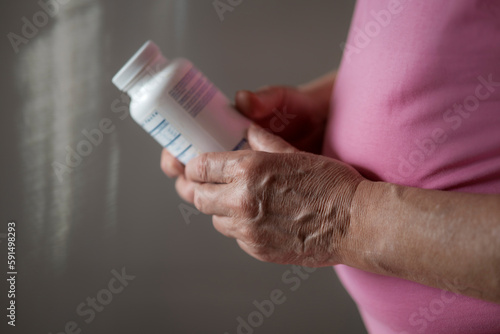 Senior man holding bottle of vitamins and probiotics photo