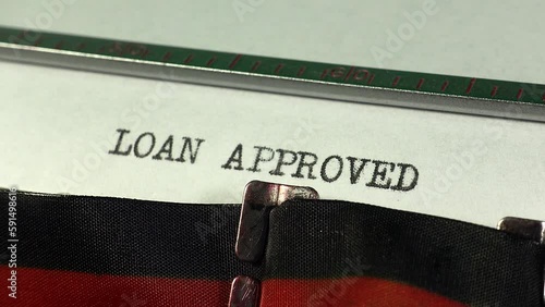 Typing Loan Approved on an old manual typewriter. Authorisation for financial credit and borrowing.