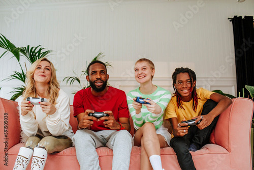 Happy diverse friends playing video game at home photo