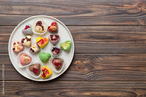 Plate with different chocolate on colored background. Assortment of fine chocolates top view vith copy space Health and obesity concept