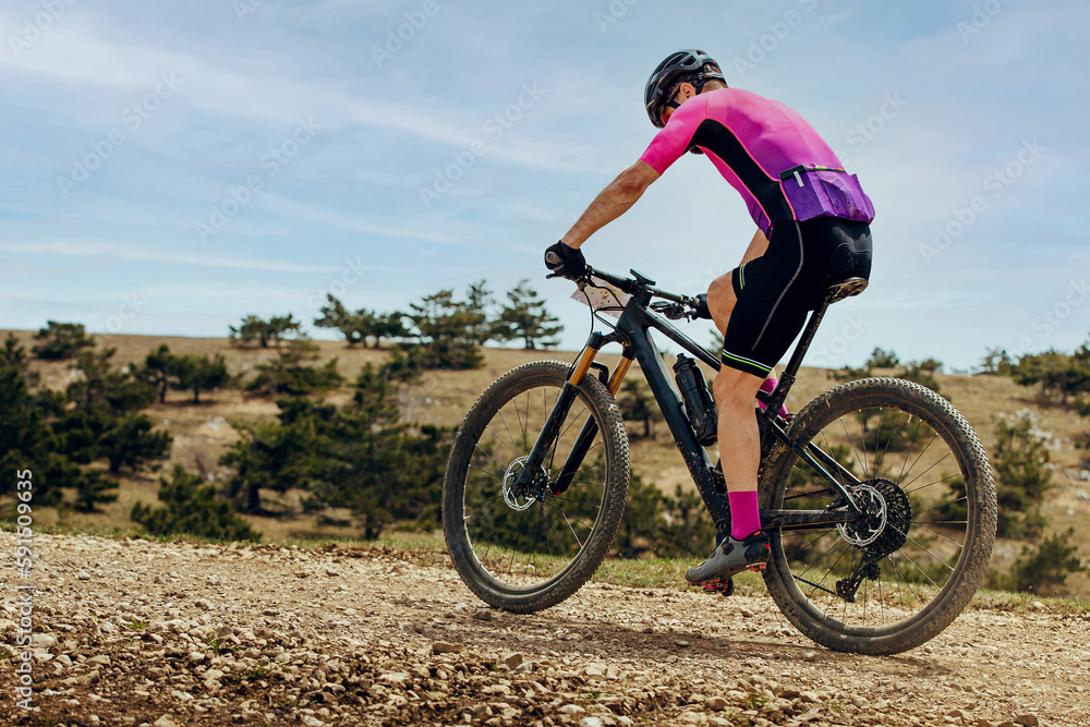 athlete mountainbiker biking uphill in cross-country cycling, outdoors summer race athlete mountainbiker biking uphill in cross-country cycling, outdoors summer race