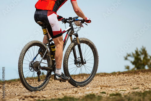 close-up mountainbiker biking uphill in cross-country cycling  outdoors summer race