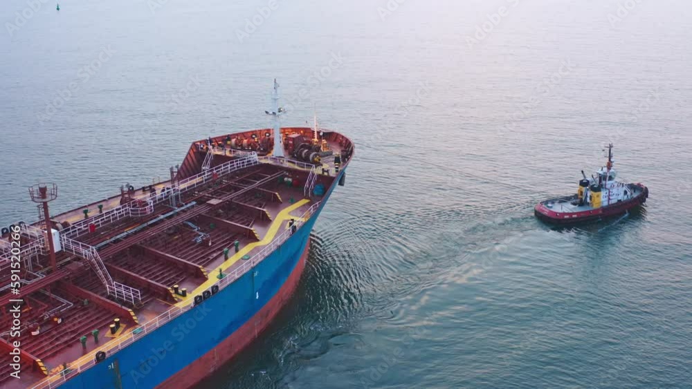 Close up Tugboat drag cargo ship near sea port aerial view. Maritime navigation and cargo transportation by sea Close up Tugboat drag cargo ship near sea port aerial view. Maritime navigation and cargo transportation by sea