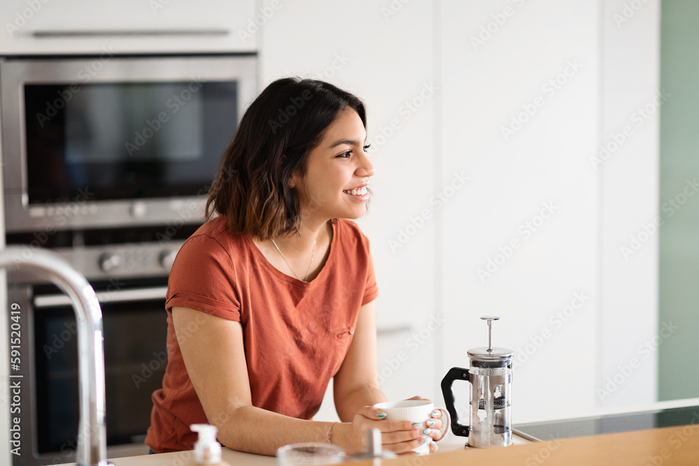 Smiling Beautiful Arab Woman Drinking Morning Coffee In Kitchen At Home