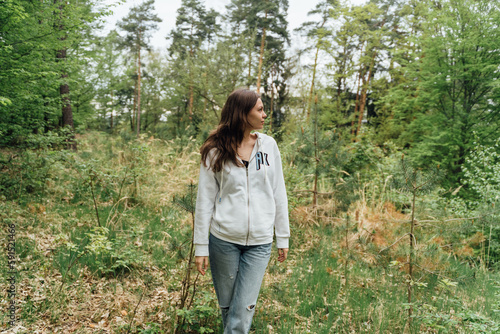 teenager gen z girl walking in the forest. close to nature concept