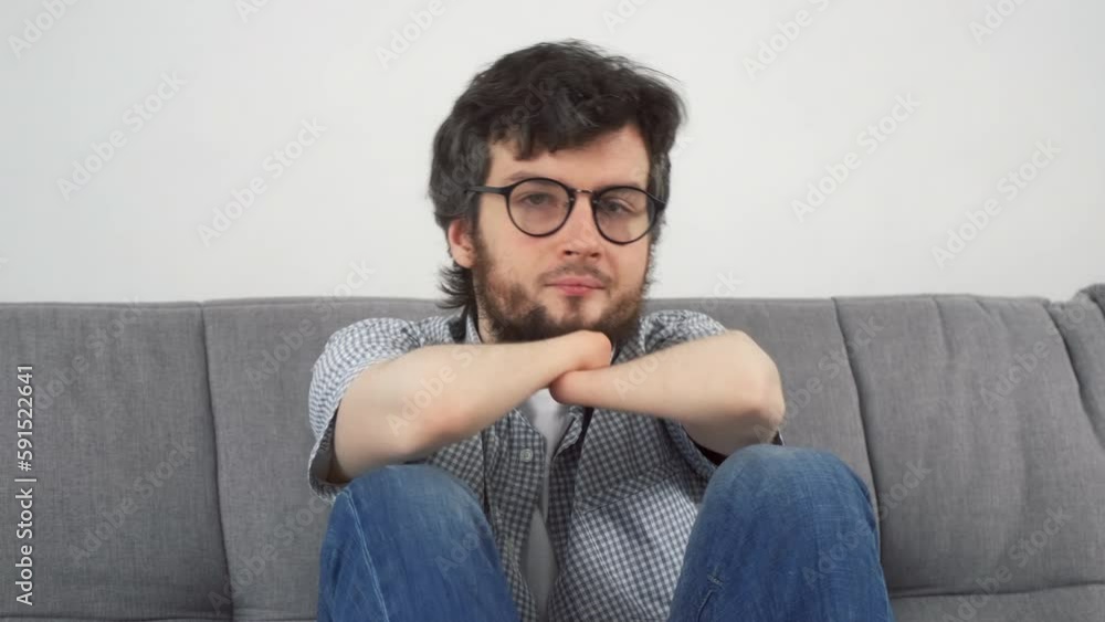 Disabled thimkful sad man with amputated two stump hands sitting on sofa and looking at camera. Problem of adaptation to life people with disabilities. Independent Invalid person. Disabled thimkful sad man with amputated two stump hands sitting on sofa and looking at camera. Problem of adaptation to life people with disabilities. Independent Invalid person.
