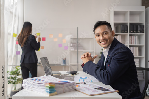 Close-up of a businessman shaking hands with a young Asian female, Work with document in the office.