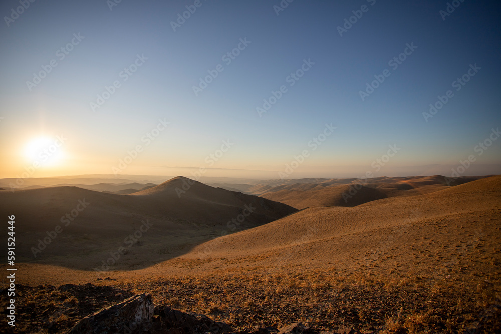 Sand dunes of the desert against the backdrop of sunrise Sand dunes of the desert against the backdrop of sunrise