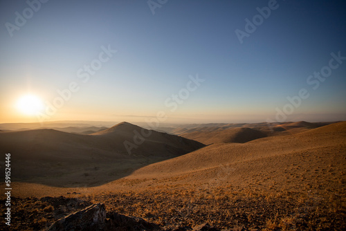 Sand dunes of the desert against the backdrop of sunrise