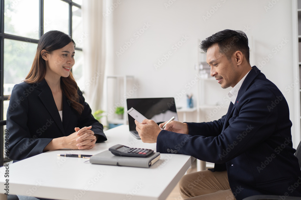 Close-up of a businessman shaking hands with a young Asian female, Work with document in the office. Close-up of a businessman shaking hands with a young Asian female, Work with document in the office.