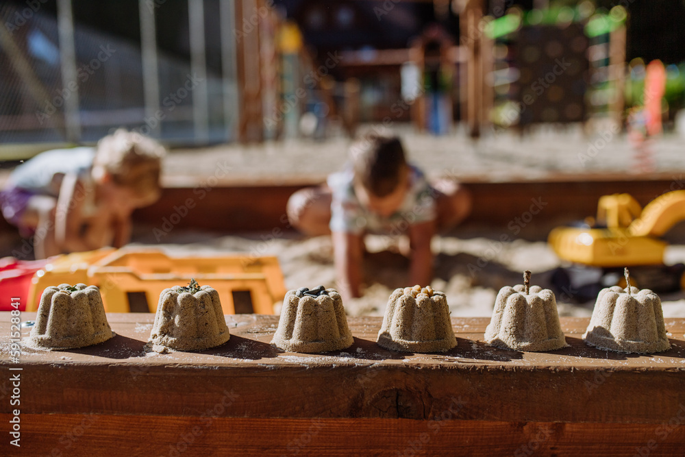 Close up of sands cake made by children in background. Close up of sands cake made by children in background.