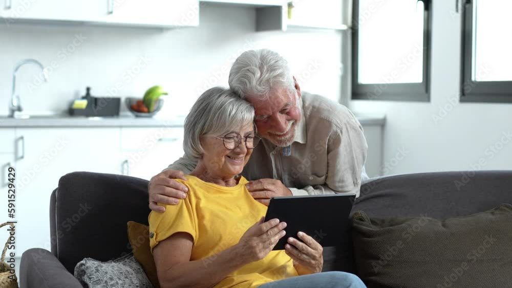 Happy older couple using computer tablet together at home, excited mature man and woman looking at mobile device screen, shopping or chatting online, sitting on cozy couch in living room
Happy older couple using computer tablet together at home, excited mature man and woman looking at mobile device screen, shopping or chatting online, sitting on cozy couch in living room