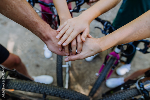 Top view of family holding hands together during bicycle trip, concept of cooperation.