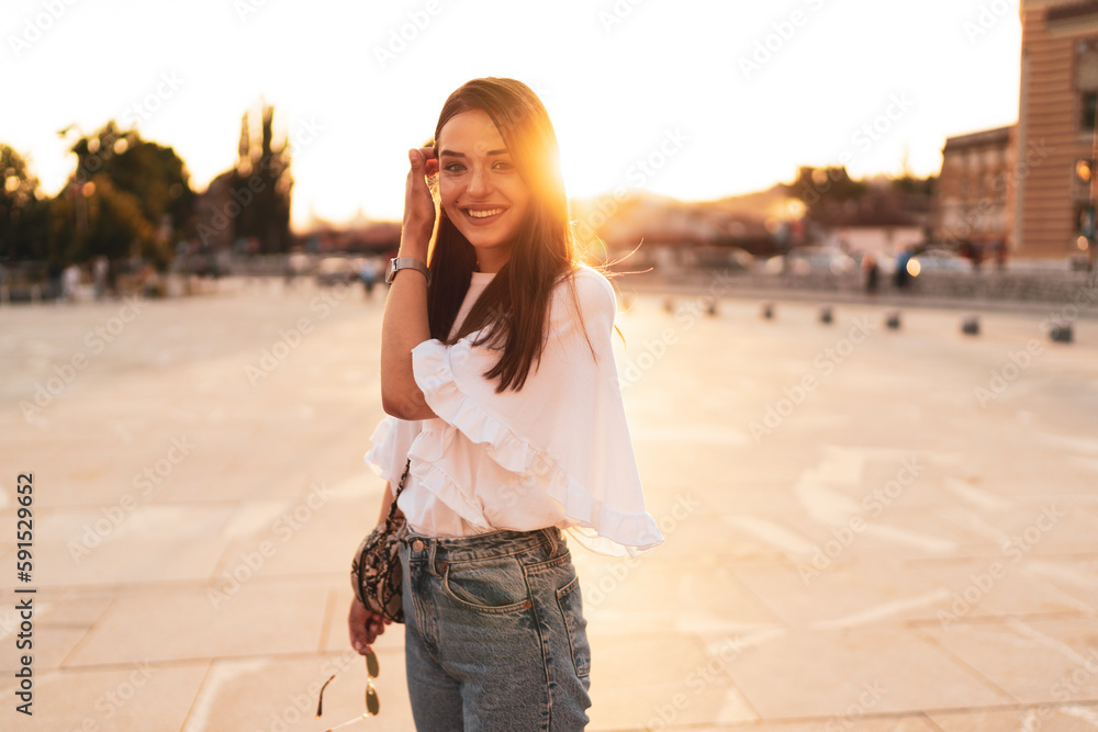 The young woman in the city at sunset
