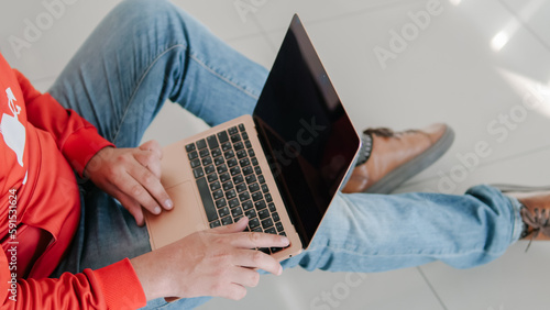 Man holding laptop and typing on keyboard