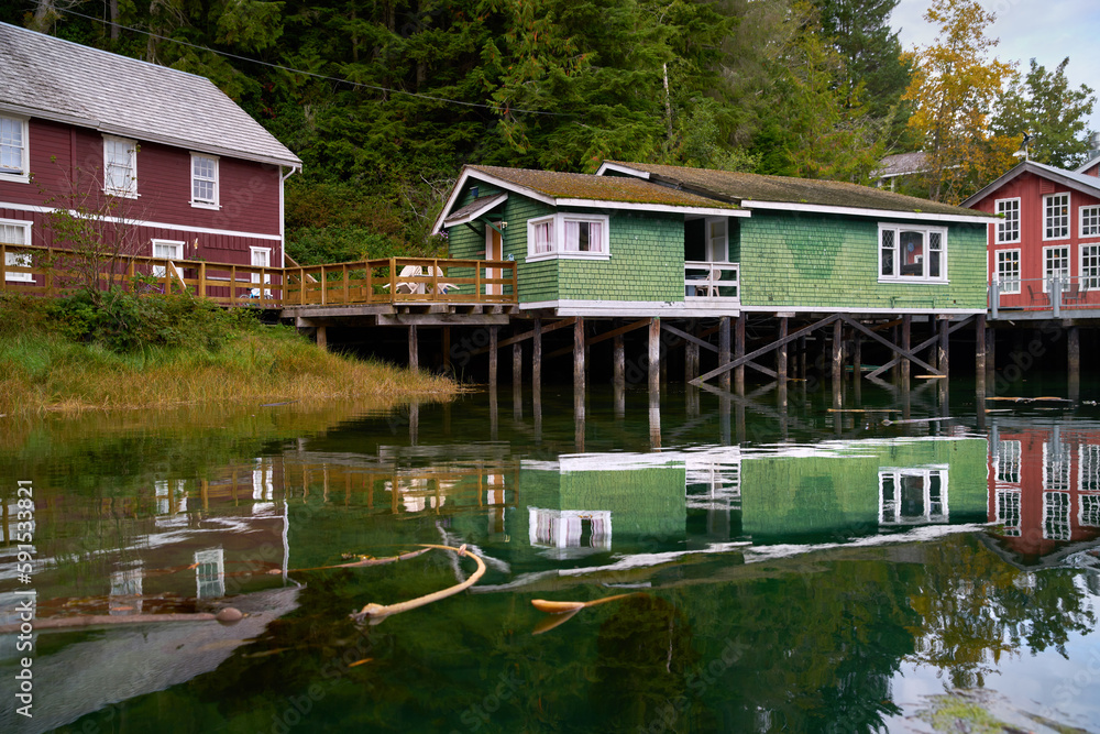 Boardwalk Accommodations on Pilings Historic Telegraph Cove. The Telegraph Cove boardwalk and accommodations built on pilings reflecting in the water surrounding this historic location.

