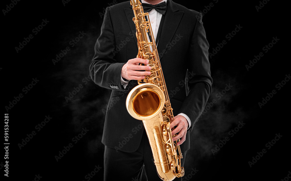 Naklejka premium Saxophonist on a black background close-up.