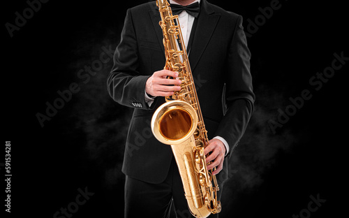 Saxophonist on a black background close-up.