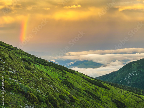 Rainbow and sunset clouds in Carpathian mountains. Ukraine