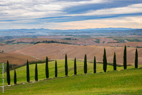 Beautiful Italian Landscape in Tuscany with famous cypress trees and interesting sky. Tuscany in autumn.