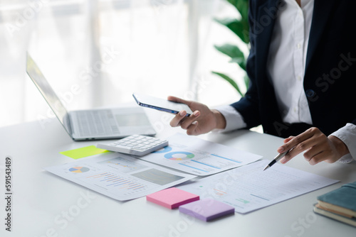 A female financier is reviewing company financial documents, monthly financial statement summary from the finance department. The concept of managing the company's finances for accuracy and growth.