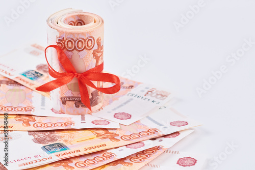 Russian rubles five thousand banknotes, bundle of money with red ribbon on white background, gift concept