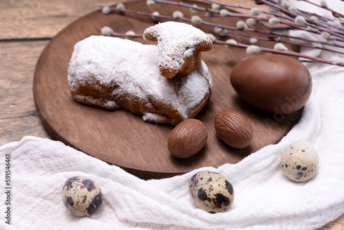Easter Sweet Lamb Pound Cake Sprinkled With Powdered Sugar, Quail and Chocolate Eggs On Wooden Table, Willow Branches. Traditional Easter Food Concept. Horizontal Plane