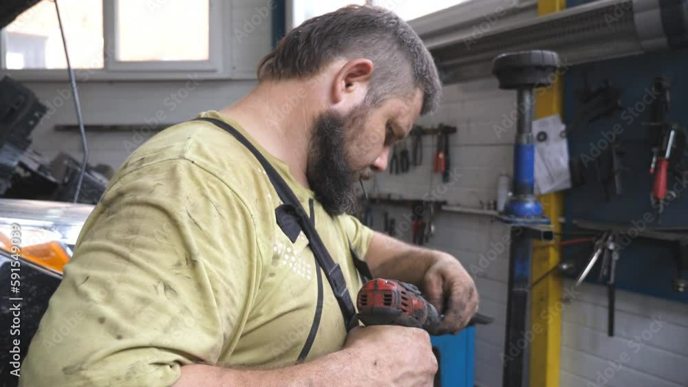 Mechanic fixing auto part with electrical tool at service. Professional repairman preparing detail before instal at car at workshop. Man repair automobile at garage. Concept of vehicle maintenance Mechanic fixing auto part with electrical tool at service. Professional repairman preparing detail before instal at car at workshop. Man repair automobile at garage. Concept of vehicle maintenance