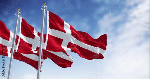 Three Denmark national flags waving in the wind on a clear day photo
