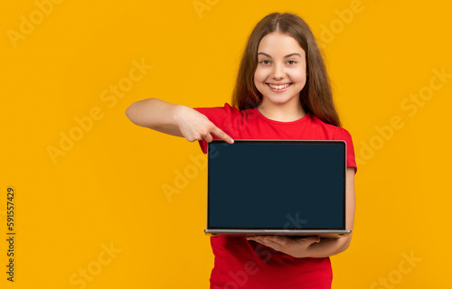happy girl with laptop on yellow background