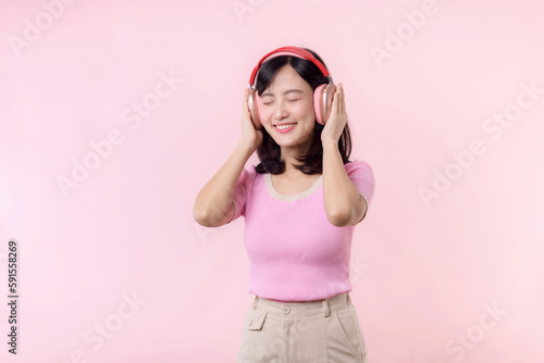 Smile pretty model person listen music song and enjoy dance with wireless headphone online audio radio sound. Positive fun exited joyful youth female woman sing on pink isolated background studio