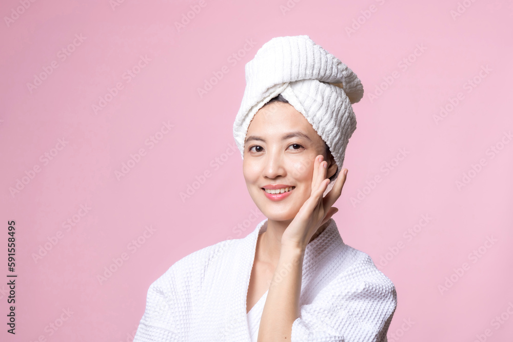 Beautiful young asian woman happy with clean face skin in towel and bathrobe, spa suit on pink background. Skincare, treatment, wellness therapy, facial care, beauty female health, cosmetology concept Beautiful young asian woman happy with clean face skin in towel and bathrobe, spa suit on pink background. Skincare, treatment, wellness therapy, facial care, beauty female health, cosmetology concept