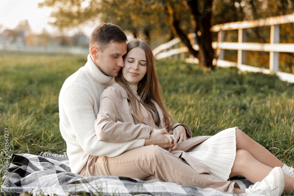 Mothers day. Stylish marriage pregnant couple waiting for baby. Man hugs and touches woman belly outdoors on plaid on grass. Family day. Pregnancy, parenthood, motherhood, love, family concept. Mothers day. Stylish marriage pregnant couple waiting for baby. Man hugs and touches woman belly outdoors on plaid on grass. Family day. Pregnancy, parenthood, motherhood, love, family concept.