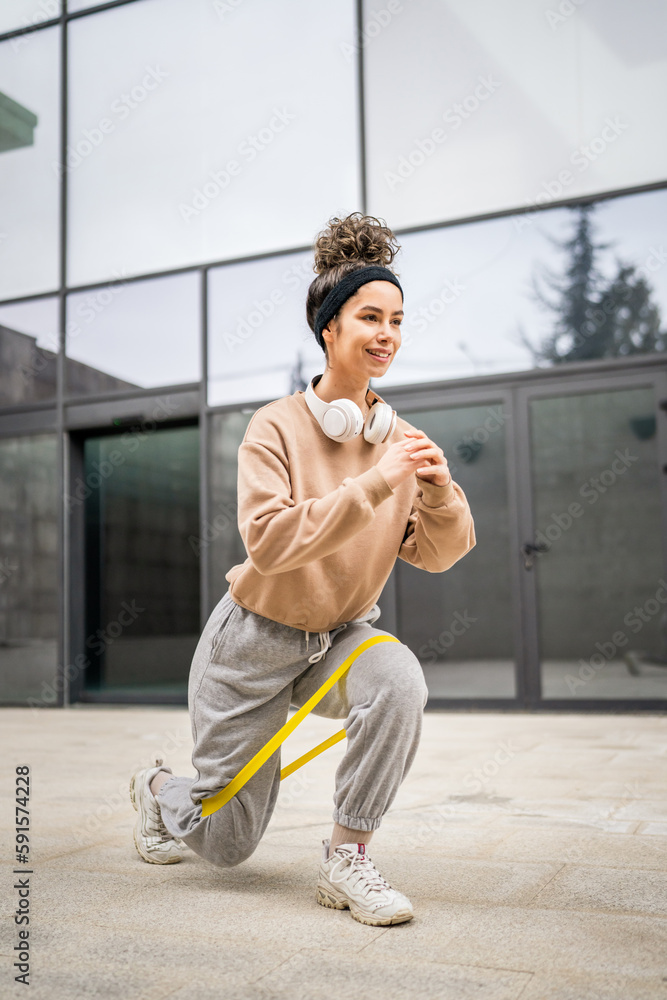 One woman training with elastic rubber resistance bands outdoor One woman training with elastic rubber resistance bands outdoor