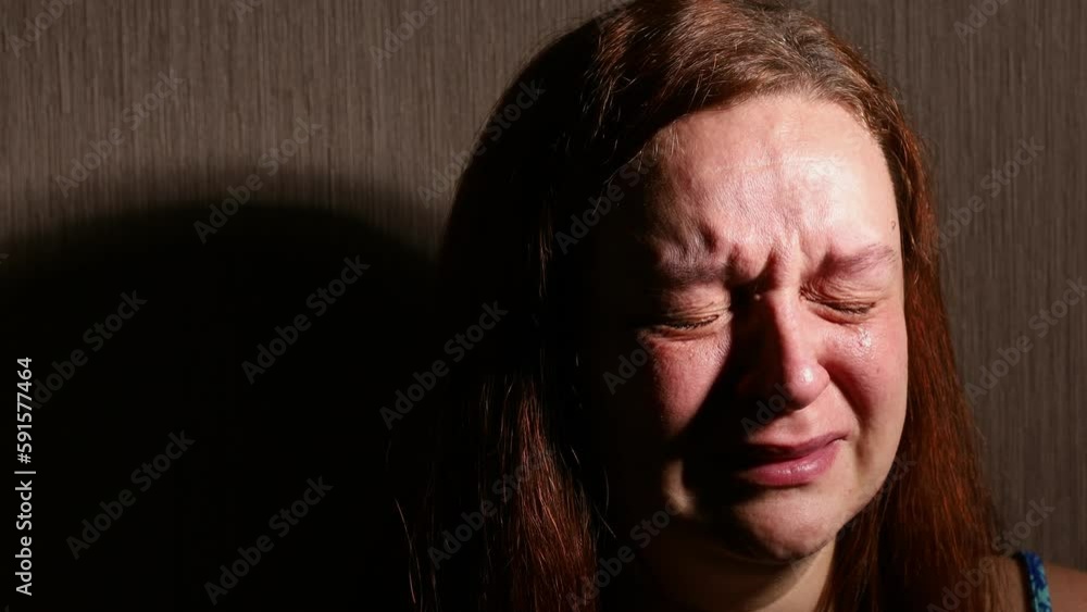 Woman hysterically cry in dark room closeup. Tears rolling down cheeks