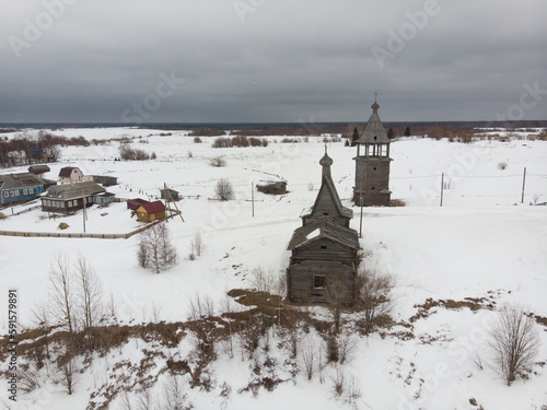 Village on the edge of a cliff. Church and bell tower on the banks of the Northern Dvina. Russia, Arkhangelsk region, Chukhcherma village