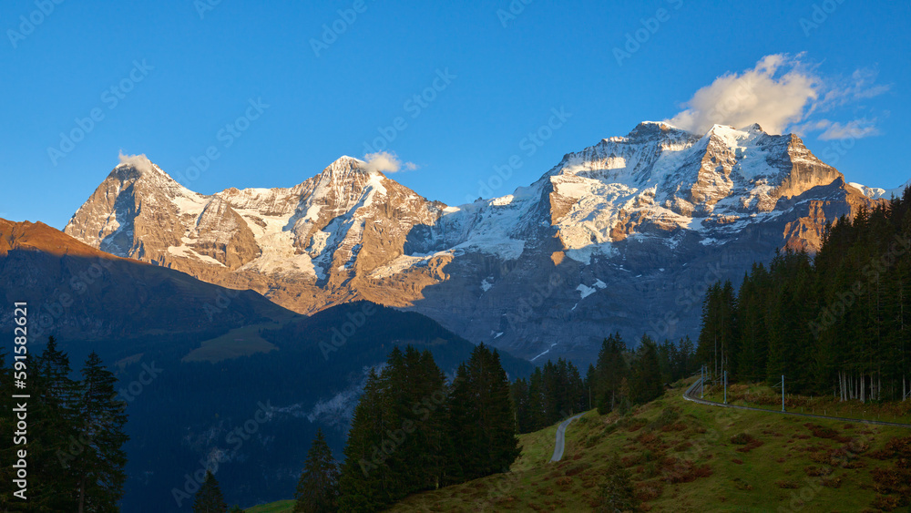 Fototapeta premium Mountain view of Jungfrau, Monch, Eiger peaks at sunset in Switzerland Bernese region.