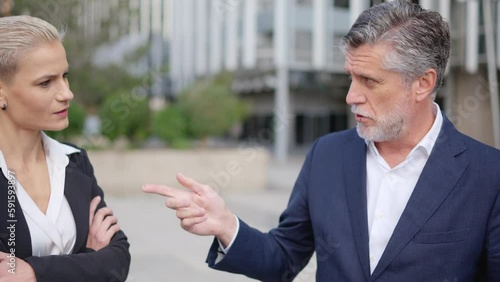 Boss gives a task to a businesswoman in the street photo