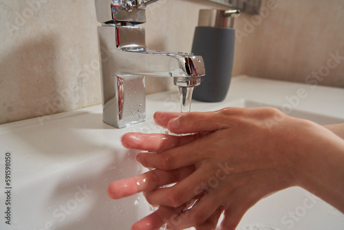 Close-up of the hands of a girl washing them in the bathroom