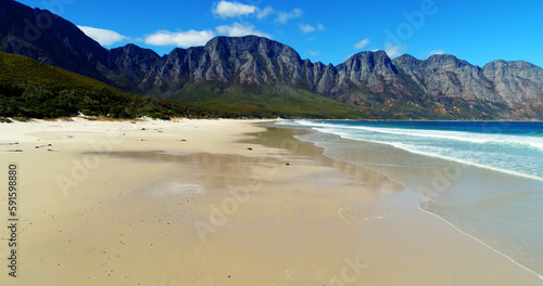 Scenic view of beach and sea by mountains 