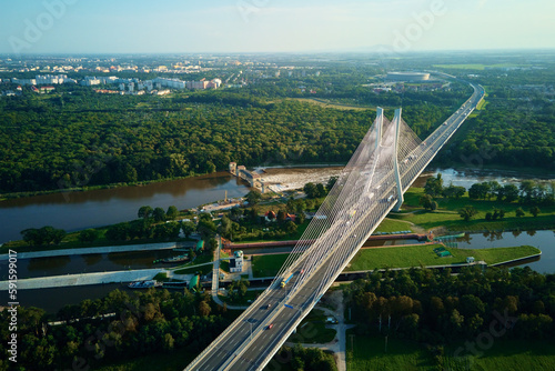 Aerial drone view of Redzinski bridge over Odra river in Wroclaw city, Poland. Large cable stayed bridge with car traffic in european city, bird eye view. Transportation infrastructure and logistic