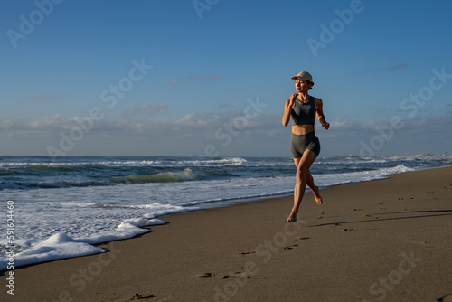 beautiful young girl is engaged in jogging on the seashore front view