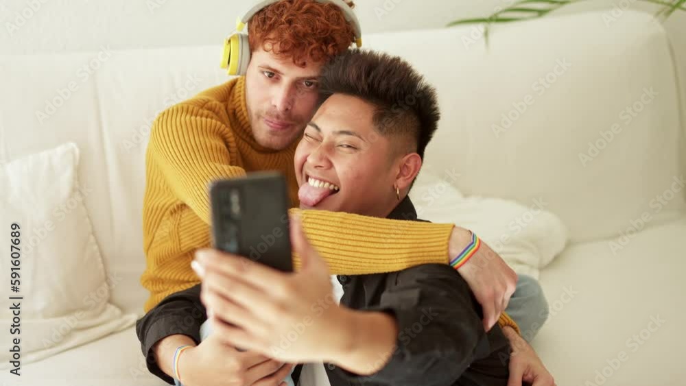 Gay couple embracing and smiling while taking selfie together Gay couple embracing and smiling while taking selfie together