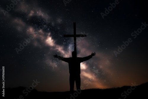 Christian cross symbol on the starry night sky with the silhouette of a person with arms raised worshiping God
